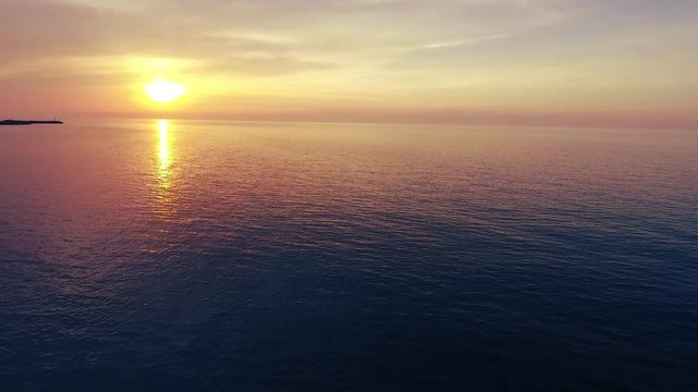 Shot of a beautiful summer sunset at the beach. Sunset at sea drone footage 