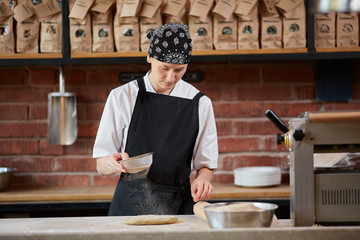 Woman add flour to dough