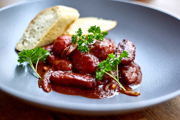 warm salad with chicken liver and grapes on the white plate. Warm salad from turkey liver. Warm salad with chicken liver in raspberry sauce.