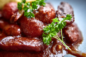 warm salad with chicken liver and grapes on the white plate. Warm salad from turkey liver. Warm salad with chicken liver in raspberry sauce.