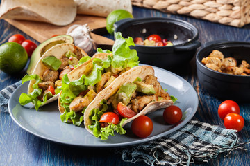 Authentic mexican tacos with chicken and salsa with avocado, tomatoes and chillies