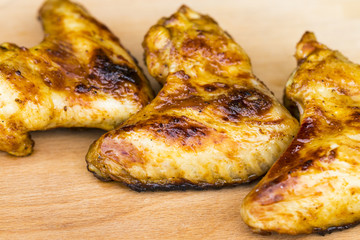 barbecue chicken wings close up on wooden tray shot with selective focus