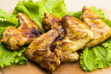 barbecue chicken wings close up on wooden tray shot with selective focus