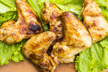 barbecue chicken wings close up on wooden tray shot with selective focus
