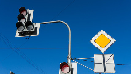 Traffic light with red light against the blue sky. Shallow depth of field.