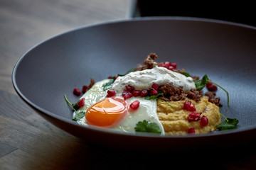 Breakfast - fried egg, beans, tomatoes, mushrooms, garnet. Mexican fried eggs huevos rancheros and ingredients close-up on the table.