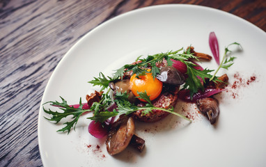 Healthy Beet Salad with fresh sweet baby spinach, kale lettuce, nuts, feta cheese and toast melted. Fresh salad with beets, closeup. Beetroot (beet) chopped for salad in bowl over rustic wooden table.