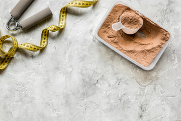 Fitness nutrition with bars and measure tape on stone background top view mock-up