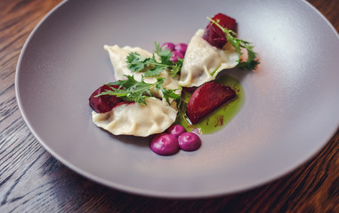 Dumplings and parsley - russian pelmeni - italian ravioli - isolated on white with clipping path. Russian national ravioli with dill on a plate.