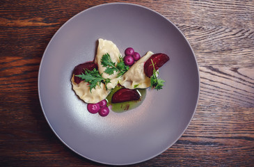 Dumplings and parsley - russian pelmeni - italian ravioli - isolated on white with clipping path. Russian national ravioli with dill on a plate.