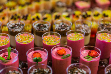 Buffet mousse dessert in a little glass topped with chocolate chips. mousse dessert in a little glass. Strawberry mousse