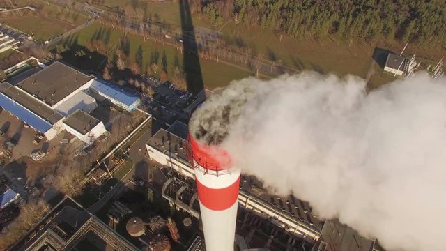 White smoke from the chimney of thermal power station boiler room, thermal power plant, aerial survey, white smoke against a blue sky. 4K. Drone footage.