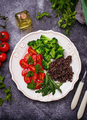 Salad with black quinoa, cherry tomatoes, broccoli and arugula