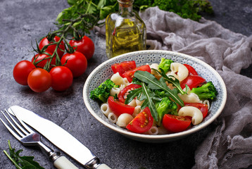Salad with pasta, tomatoes, broccoli and arugula