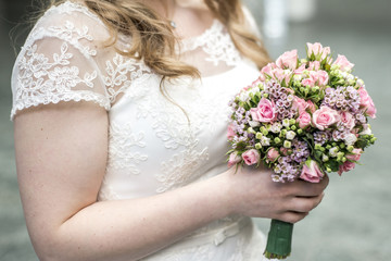 Wedding bouquet of flowers held by a bride. Pink, yellow and Green