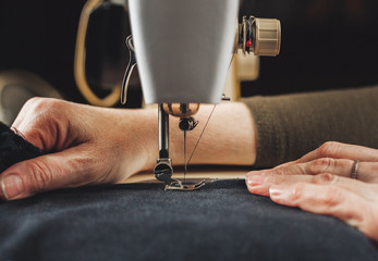 Woman working with sewing machine - obrazy, fototapety, plakaty