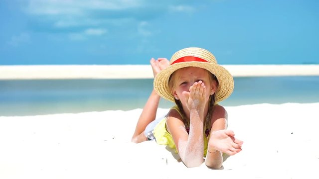 Little girl in hat at the beach during caribbean vacation. SLOW MOTION.