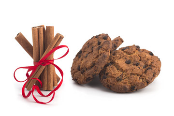 Biscuits with chocolate, festive cinnamon sticks on white background