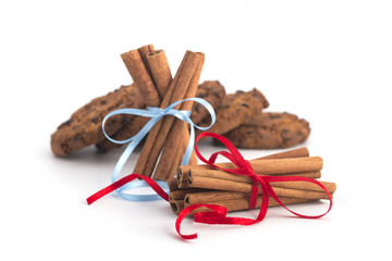 Biscuits with chocolate, festive cinnamon sticks on white background