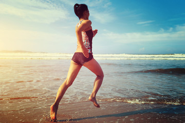 young fitness woman wear swimsuit running on beach