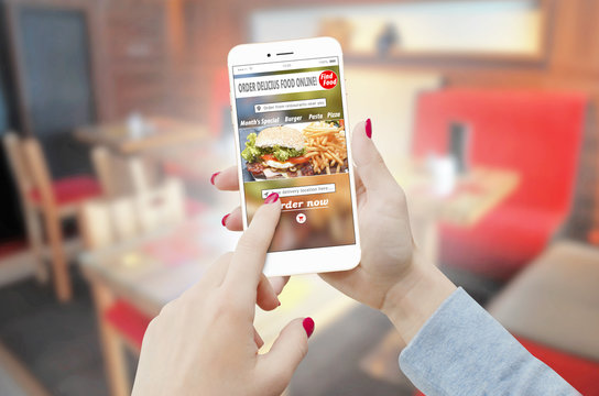 Close-up of a female hands ordering food with a phone in restaurant. Food order concept