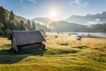 View over Geroldsee with wooden hut and Karwendel mountains at early morning in autumn, Bavaria,...