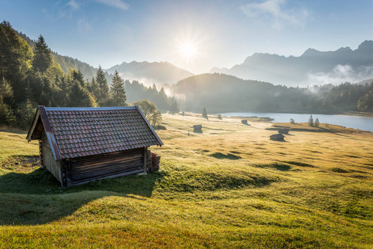 View over Geroldsee with wooden hut and Karwendel mountains at early morning in autumn, Bavaria, Germany