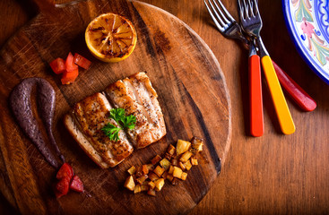 Pan Fried Fish with Grilled Lemon on Wooden Table and Board