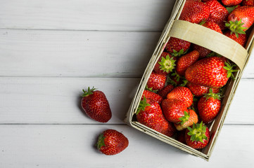 Punnet full of fresh ripe strawberries on white background
