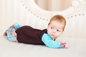 Portrait of a cute newborn baby lying on its stomach and smiling