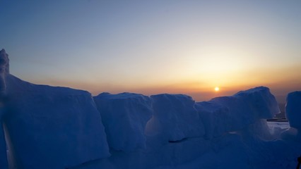 テント周囲に設けた防風壁ごしに朝日を見る