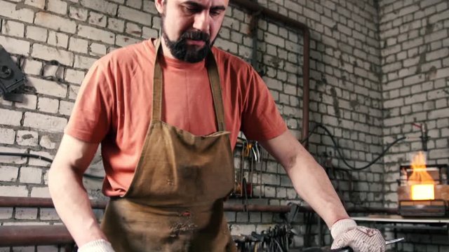 Blacksmith melts metal in the furnace
