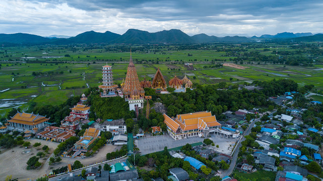 Aerial view from the pagoda, golden buddha statue with rice fields and mountain background