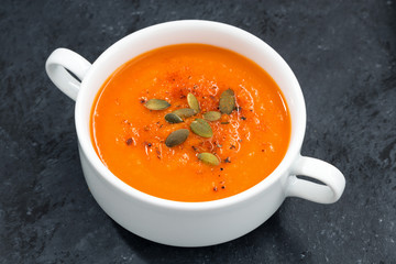 pumpkin cream soup on a dark background, top view, closeup