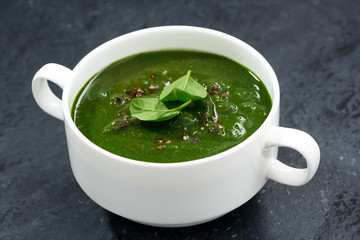 spinach cream soup on a dark background, closeup