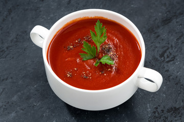 tomato cream soup on a dark background, top view