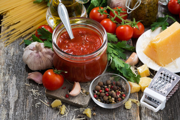 tomato sauce and ingredients on a wooden background