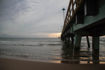 Pier on the beach with cloudy sky in morning