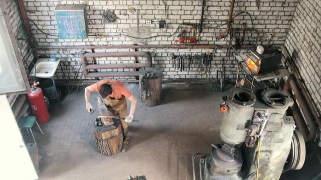 The blacksmith bears a red-hot rod