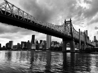 Queensboro bridge over the river and buildings in black and white style, New York