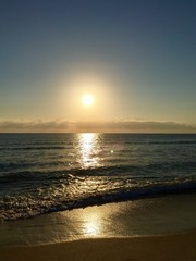 Fototapeta premium Sunrise reflects on the dark beach