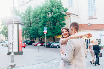 Stylish young couple in love walking on the street at sunset