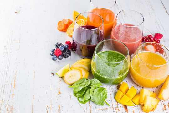 Selection of colourful smoothies on rustic wood background