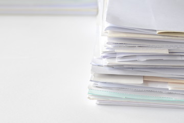 Stack of financial documents on white table with copy space for text,high key tone.