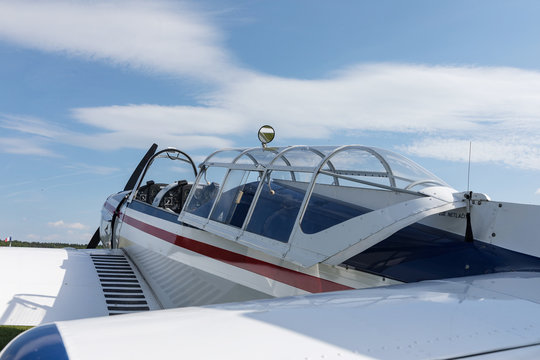 Two seat single engine civil utility aircraft, white small plane, red and blue strip is towed by a glider on a sunny day