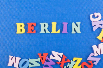 BERLIN word on blue background composed from colorful abc alphabet block wooden letters, copy space for ad text. Learning english concept.