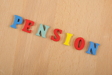 PENSION word on wooden background composed from colorful abc alphabet block wooden letters, copy space for ad text. Learning english concept.