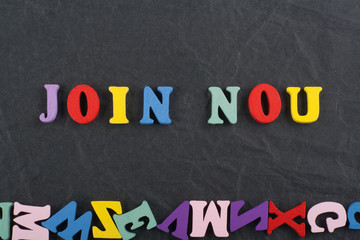 JOIN NOW word on black board background composed from colorful abc alphabet block wooden letters, copy space for ad text. Learning english concept.
