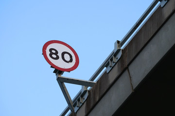 Round speed limit sign at 80 on a highway