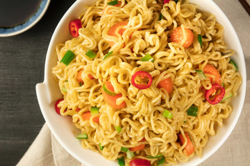Overhead closeup of bowl of instant noodles with vegetables